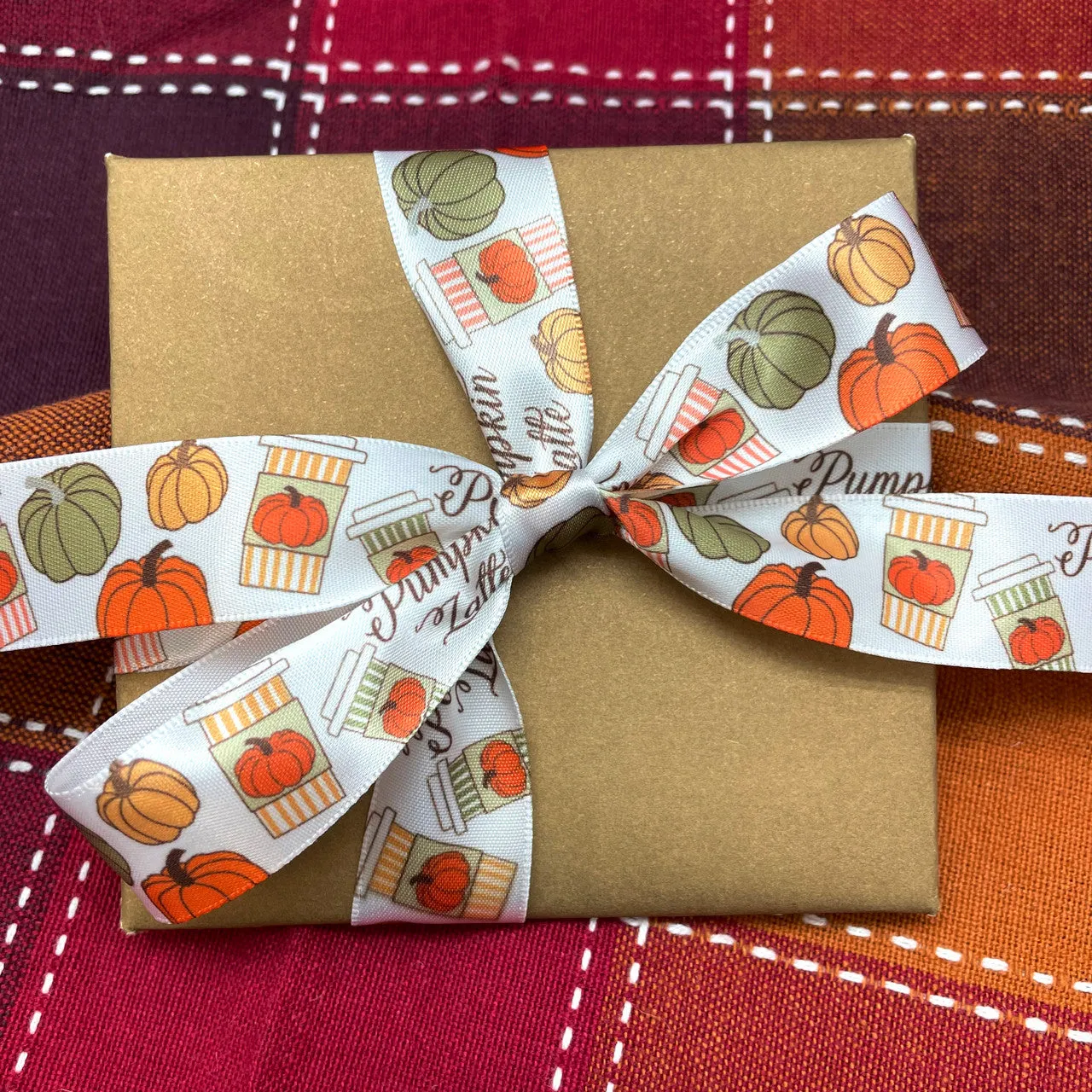 Pumpkin Latte ribbon with  brown script, orange striped coffee cups, and tossed pumpkins printed on 7/8" white satin ribbon